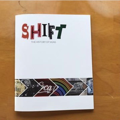 Cover of SHIFT: The History of Signs, with multicolored sign-style lettering and a band of sign photographs